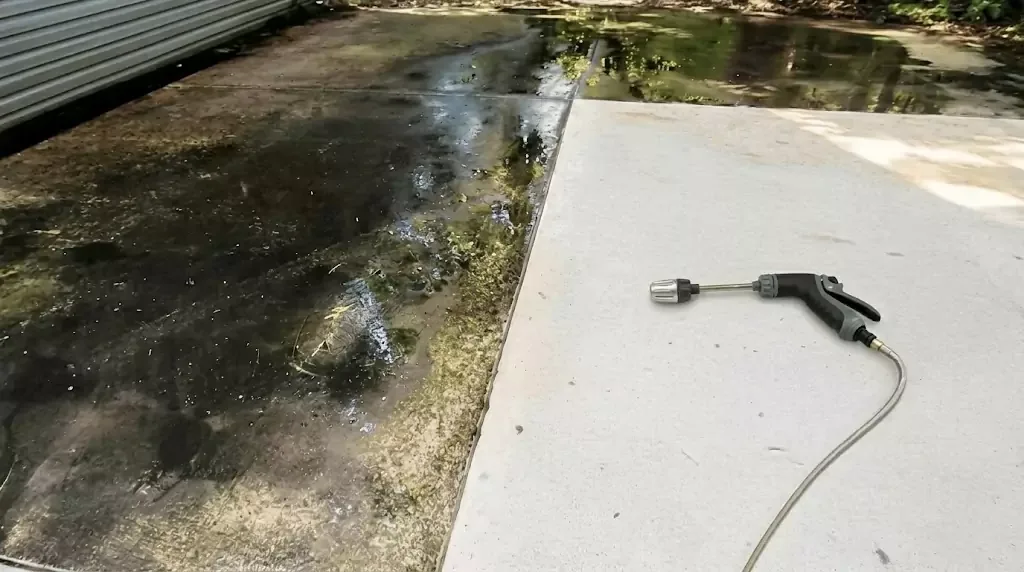 Power Blast test on a narrow concrete strip with years of algae buildup — clear cleaned line through the dirty area